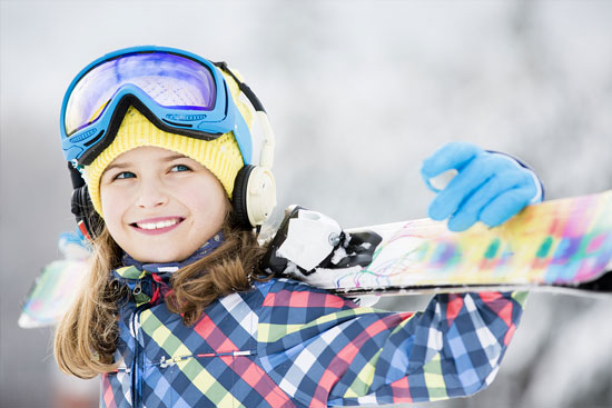 Happy pediatric girl snowboarding after getting started with the diagnostic assessment at Aris Clinic