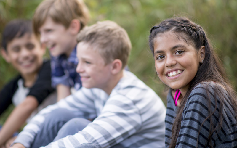 Kids outside in summer having a good time and smiling.